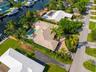 Waterfront property featuring a private boat dock, extensive landscaping, swimming pool, and concrete tile roofing