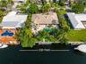 Waterfront property featuring a private boat dock, in-ground swimming pool, and extensive paved patio