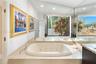 Built-in jetted tub with polished chrome fixtures, integrated into a stone-finish countertop