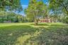 Expansive green space featuring a variety of mature trees and landscaping
