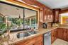 Kitchen featuring wooden cabinetry, granite countertops, stainless steel appliances, and a double basin sink