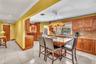 Kitchen featuring a central island, wood cabinetry, stone countertops, and tile flooring