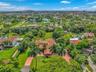 Expansive property featuring a red tile roof, mature palm trees, and a substantial driveway