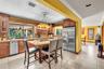 Kitchen featuring wood cabinetry, stainless steel appliances, a built-in cooktop island, and a large window