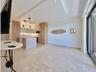 Open-concept living space with light-toned flooring, recessed lighting, and a modern kitchen