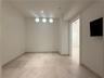 Recessed ceiling lighting, three flush-mount wall sconces, neutral wall paint, and stone tile flooring