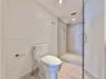 Full glass-enclosed shower with a rainfall showerhead, handheld shower fixture, and polished chrome hardware