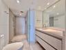 Floating vanity with a light-toned countertop, under-mount sink, and contemporary faucet