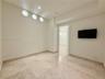 Recessed lighting, three circular wall cutouts, light-toned stone tile flooring, and a cased doorway