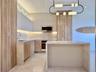 Kitchen featuring wood-finish cabinetry, stainless steel appliances, stone countertops, and an integrated island