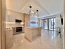 Contemporary kitchen with integrated appliances, light-toned cabinetry, and a stone-clad island
