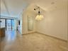 Recessed lighting, contemporary chandelier, full-height mirror, and tile flooring