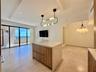 Expansive sliding glass doors, built-in kitchen island with stone countertop, and recessed lighting