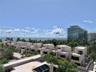 Modern low-rise buildings with multiple balconies, surrounded by lush tropical landscaping