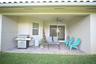 Covered patio with brick paver flooring, sliding glass door, and ceiling fan