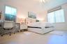 Light wood-finish flooring, white walls, and a ceiling fan with light fixture
