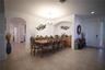 Tiled flooring throughout, featuring an arched entryway, a built-in wet bar, and a paneled front door with a textured glass sidelight