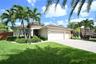 Stucco exterior with a tile roof, a two-car garage, and a paver driveway