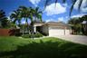 Mediterranean-style exterior with a tile roof, an integrated two-car garage, and a paver driveway