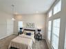 High ceilings with recessed lighting, carpet flooring, multiple windows with blinds, and a paneled interior door