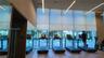 Floor-to-ceiling windows with roller shades, wood-finish flooring, recessed linear lighting, and integrated mirrors