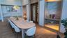 Wood-finish flooring, built-in cabinetry with stone countertop and backsplash, modern chandelier, built-in shelving with accent lighting, and a wood-p