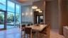 Expansive floor-to-ceiling windows, patterned accent wall, recessed lighting, modern pendant lighting, and wood-slat wall paneling