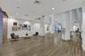 Spacious common area featuring wood-finish flooring, recessed lighting, and white support columns