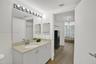 Vanity with a single basin, light-toned countertop, and integrated storage cabinetry