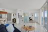 Expansive floor-to-ceiling glass sliding doors, glossy tile flooring, and integrated wall shelving