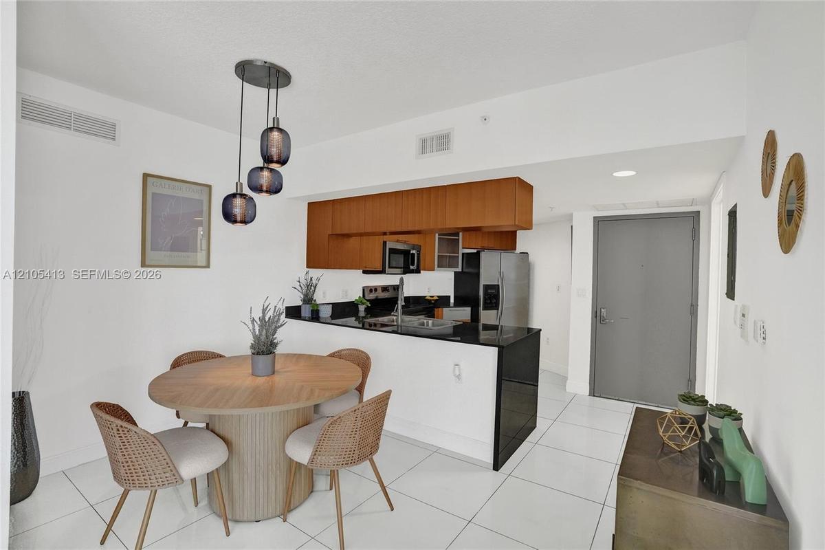 Kitchen with black countertops, stainless steel appliances, and wood-finish cabinetry