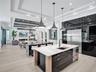 Tray ceiling with dark wood-finish plank detailing, linear electric fireplace, built-in display shelving, wood-finish flooring, and multi-panel slidin