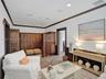 Custom built-in closet organization featuring high-gloss cabinetry, floor-to-ceiling shelving, multiple hanging rods, and integrated recessed lighting
