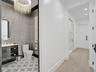 High-gloss black cabinetry, expansive white stone countertops, stainless steel professional-grade range with a matching range hood, and three oversize