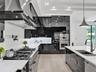 Textured floor-to-ceiling fireplace surround, horizontal linear fireplace, and integrated dark-toned display shelving with recessed lighting