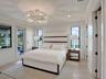Statement wall featuring book-matched stone cladding with dark border detailing and a contemporary tiered chandelier