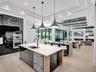 Tray ceiling with dark wood-finish planking, linear gas fireplace, built-in recessed shelving, integrated lighting, and light-toned flooring