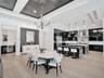 Open-concept kitchen and dining area featuring wood-finish flooring, a tray ceiling with charcoal-toned wood plank inlay, a custom kitchen island with