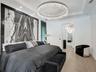 Curved floor-to-ceiling windows with black frames, wood-finish flooring, modern starburst chandelier, and crown molding