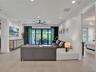 High-gloss black cabinetry, professional-grade stainless steel range with a custom hood, quartz countertops, built-in double wall ovens, and wood-fini