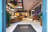 Lobby featuring large-scale ceiling artwork, a curved reception desk, custom pendant lighting, expansive tile flooring, and integrated wall installati