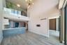 Double-height ceiling, glass-paneled mezzanine railing, wood-finish flooring, kitchen island with solid surface countertop, and modern multi-arm penda