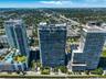 High-rise residential towers featuring glass-paneled balconies, expansive floor-to-ceiling windows, and rooftop terrace levels