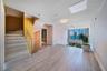 Staircase with wood-finish treads, glass railing, floor-to-ceiling windows, and wood-finish flooring