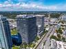 High-rise residential towers featuring wrap-around balconies, glass-paneled railings, exterior concrete structural elements, rooftop recreational spac