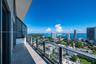 Private balcony featuring wood-finish tile flooring, glass panel railings, and a metal frame