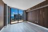 Floor-to-ceiling windows, wood-slat accent walls, wood-finish flooring, and a private balcony