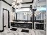 Polished high-contrast black and white stone surfacing featuring a bold brecciated pattern, set against light-toned wood-finish flooring