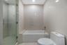 Bathroom featuring a separate glass-enclosed shower, built-in soaking tub with a deck, and large-format tile wall cladding
