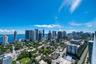 Elevated balcony perspective featuring glass railing, panoramic city skyline, and waterfront scenery